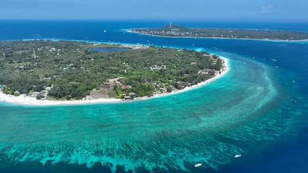 Sığ resifler ve derin mavi sularla çevrili bir mercan adası anteni..