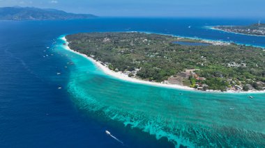 Sığ resifler ve derin mavi sularla çevrili bir mercan adası anteni..