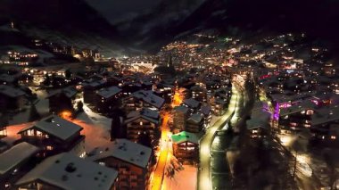 Zermatt 'ta karla kaplı tepelerdeki tipik renkli İsviçre evlerinin gece görüşü. Kış boyunca İsviçre 'nin Zermatt kentindeki Avrupa Alpleri' ndeki Kayak Kasabası 'nın yukarıdan görüntüsü.