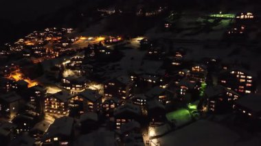 İsviçre Alpleri, İsviçre ve Avrupa 'daki güzel bahar gününde sakin köy ve St Mauritius kilisesine bakan Zermatt üzerinde gece uçuyor..