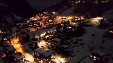 İsviçre Alpleri, İsviçre ve Avrupa 'daki güzel bahar gününde sakin köy ve St Mauritius kilisesine bakan Zermatt üzerinde gece uçuyor..