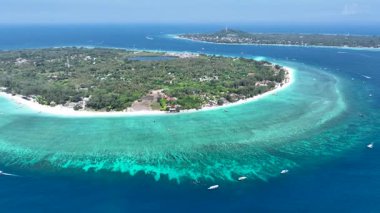 Sığ resifler ve derin mavi sularla çevrili bir mercan adası anteni..