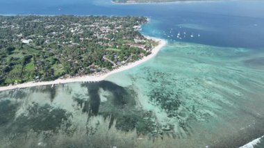 Sığ resifler ve derin mavi sularla çevrili bir mercan adası anteni..