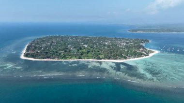 Sığ resifler ve derin mavi sularla çevrili bir mercan adası anteni..