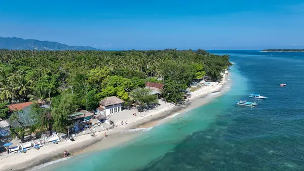 Gili Havası 'nın huzurlu kıyı şeridinde turkuaz sular, beyaz kumlu plajlar ve tropik bir adada huzurlu bir kaçış sunan büyüleyici sahil kulübeleri yer alıyor..