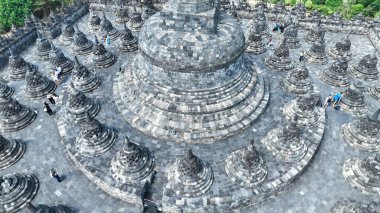 Endonezya 'nın merkez Java kentindeki UNESCO Dünya Mirası Alanı Borobudur Tapınağı' ndaki antik taş stupaların yakın görüntüsü. Açık mavi gökyüzü, karmaşık Budist mimarisine zıtlık katar..