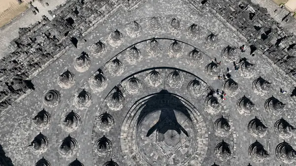 Borobudur görkemli sersemlikleri, tapınağın uysal simetrisini ve zamansız Budist sanatını yukarıdan aydınlatan antik taşın üzerine dramatik gölgeler serpiştirdi..