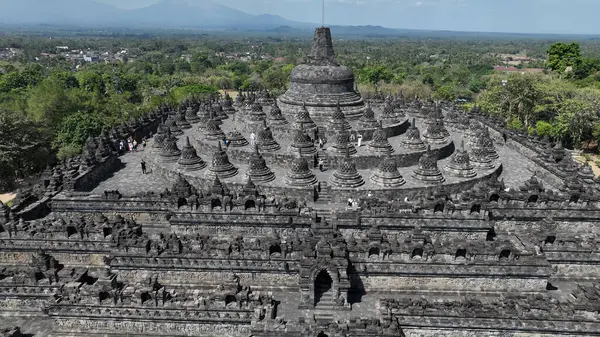 Dünyanın en büyük Budist tapınağı olan Borobudur 'un nefes kesen bir havası, zengin Java manzaralarına karşı kurulmuş karmaşık taş taş taş taş taş taş taş taşlarını ve simetrik teraslarını gözler önüne seriyor..