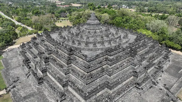 Bu hava görüntüsünde Nirvana yolunu sembolize eden eş merkezli platformlar ve stupalar ile Borobudurs ikonik mandala düzeni sergilenmektedir..