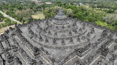 Dünyanın en büyük Budist tapınağı olan Borobudur 'un görkemli simetrisi, bu nefes kesen hava manzarasında yemyeşil Java manzaralarının üzerinde yükseliyor..