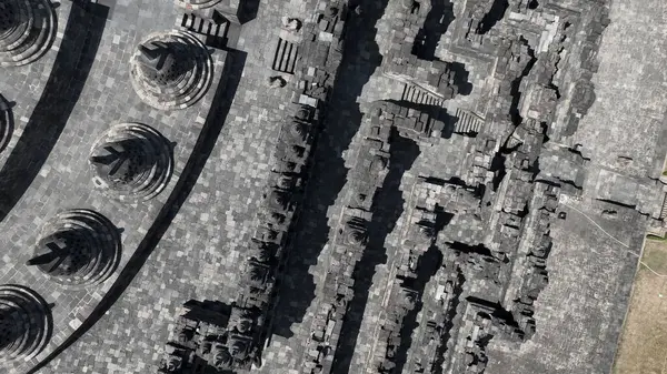 Yakın plan hava görüntüsü Borobudur teraslarının karmaşık taş işçiliğini ve geometrik hassasiyetini gözler önüne seriyor, manevi sembolizm ve mimari dehanın tapınak uyumunu gözler önüne seriyor..