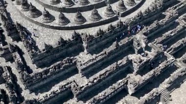 Labirent koridorları ve Borobudur 'un detaylı taş işçiliği yukarıdan ele geçirilerek tapınakların etkileyici boyutları ve kutsal tasarımın karmaşıklığı vurgulandı..