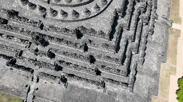 Labirent koridorları ve Borobudur 'un detaylı taş işçiliği yukarıdan ele geçirilerek tapınakların etkileyici boyutları ve kutsal tasarımın karmaşıklığı vurgulandı..