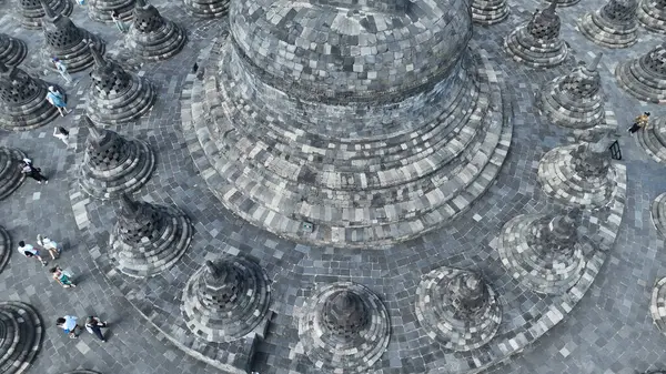 Borobudur 'teki en büyük stupa' nın etrafında taştan stupalar var. Büyük stupanın etrafındaki karmaşık detaylar yukarıdan güzelce yansıtılıyor, antik zanaatkarlığı ve geometrik uyumu gözler önüne seriyor..