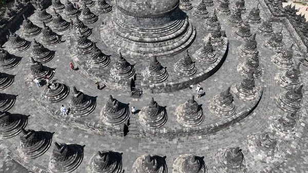 Borobudur 'a hayret edin, bu gökyüzünde, sersemliklerin ve terasların geometrik düzeni büyüleyici bir desen yaratıyor, anıtların ruhani ihtişamını gözler önüne seriyor.