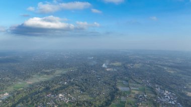 Dağınık köylerin ve pirinç tarlalarının uzadığı, uzak volkan silueti Rinjani 'nin yumuşak bulutların altında durduğu, Lombok kırsalının panoramasını süpürüyor..