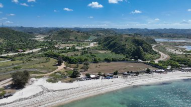 Virajlı yollar ve yemyeşil tepeler beyaz kumsal ve turkuaz sularla birleşerek rahatlama ve macera için mükemmel tropik bir manzara yaratıyor..