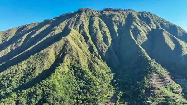 Güzel Sembalun Tepesi, Lombok Endonezya aralığı açık mavi gökyüzü ve uzakta uçan bir kuş. Huzurlu ve huzurlu bir manzara. Dağlar huzur ve sükunet hissi veriyor..