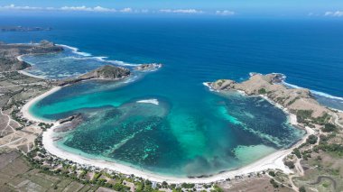 Dramatik burunlar ve beyaz kumlar tarafından çerçevelenmiş Lombok turkuaz hangarının hava manzarası. Kristal berrak su yüzeyin altındaki canlı mercan resiflerini ortaya çıkarır..