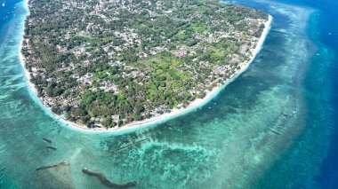 Gili Havası bu büyüleyici hava görüntüsünde parlıyor, yemyeşil manzarasını, beyaz plajlarını ve etrafındaki mercan resiflerini vurguluyor. Huzurlu ada yaşamını ve büyüleyici doğal manzarayı tecrübe edin..