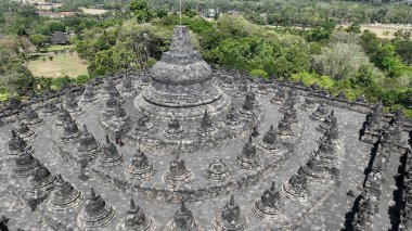 Borobudur Tapınağı 'nın büyüleyici bir görüntüsü. Bu resim, bu muhteşem Budist anıtının üst katlarını süsleyen çan şeklindeki pek çok aptaldan birini güzel bir şekilde yakalıyor..
