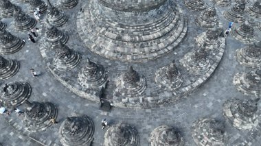 Borobudur 'teki en büyük stupa' nın etrafında taştan stupalar var. Büyük stupanın etrafındaki karmaşık detaylar yukarıdan güzelce yansıtılıyor, antik zanaatkarlığı ve geometrik uyumu gözler önüne seriyor..