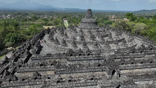 Bu hava yakın çekim Borobudurs görkemli merkezi kubbe çan şekilli stupa ile çevrili, tapınaklar üzerinde eşsiz bir perspektif sunuyor geometrik ahenk ve ruhani görkem.