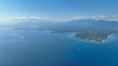 Lombok adasının çarpıcı kıyılarını yukarıdan keşfedin. Panoramik çekim, el değmemiş kumsalları, turkuaz suları ve etkileyici dağ zeminini yakalar. Lombok 'un el değmemiş cazibesini sergiler..