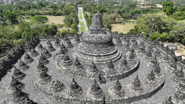 Borobudur 'un zirvesi, Endonezya' nın zengin kültürel mirasının bir vasiyeti olan taş sersemlerinden ve etrafındaki ormandan oluşan çarpıcı bir manzarayı gözler önüne seriyor..