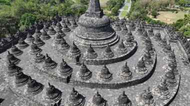 Borobudur 'un görkemli merkezi, bu antik Endonezya başyapıtında aydınlanmaya giden Budist yolunu sembolize eden çan şekilli stupalarla çevrili eşmerkezli terasların üzerinde yükselir..
