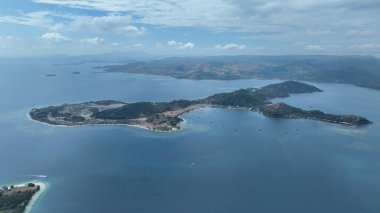 Gili Gede Adası, arka planda Lombok 'un engebeli dağlarına karşı kurulmuş eşsiz sahil şeridi, huzurlu koyları ve canlı yeşillikleriyle uzanır..