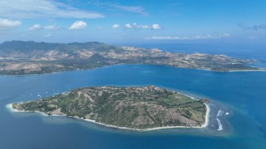 Yeşil tepeleri ve beyaz kumlu plajlarıyla Gili Asahan 'ın hava görüntüsü Lombok dağlık kıyı şeridine ve durgun mavi denize karşı çekilmiştir..