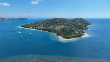 Gili Asahan 'ın kristal berrak sularda demirli yelkenli tekneleriyle muhteşem bir görüntüsü. Ada yemyeşil tepeler ve dinlenmek için mükemmel canlı bir sahil şeridine sahiptir..