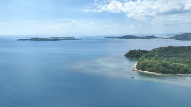 Mavi Lombok Boğazı 'na dağılmış Gili adalarının panoramik hava görüntüsü. Sakin sular ve yeşil kıyı şeritleri adaya atlama ve keşfe davet ediyor.