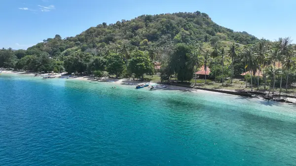 Geleneksel tekneler, yemyeşil ve nazik tepelerle çerçevelenmiş canlı mavi bir körfezin kumlu sahillerinde dinlenir. Rahatlatıcı bir ada kaçışı için mükemmeldir..