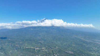 Kudretli Gunung Agung volkanını saran bulutlar Bali 'nin yemyeşil ormanlarından yükseliyor. Amed 'in manzarası dağın ihtişamını ve adanın vahşi güzelliğini yansıtıyor..