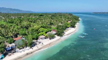 Gili Havası 'nın huzurlu kıyı şeridinde turkuaz sular, beyaz kumlu plajlar ve tropik bir adada huzurlu bir kaçış sunan büyüleyici sahil kulübeleri yer alıyor..