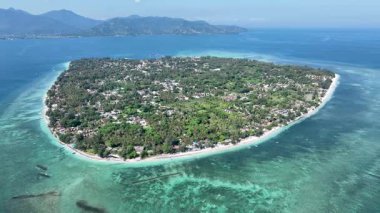 Gili Havası 'nın yemyeşil manzarası turkuaz sularla ve yakındaki dağların panoramik manzarasıyla beyaz plajlarla çevrilidir..