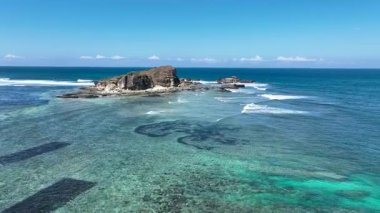 Bereketli yamaçlar, berrak suların el değmemiş kıyı şeridi boyunca mercan ve kayaları ortaya çıkardığı tenha, beyaz bir kumsala kadar uzanır..