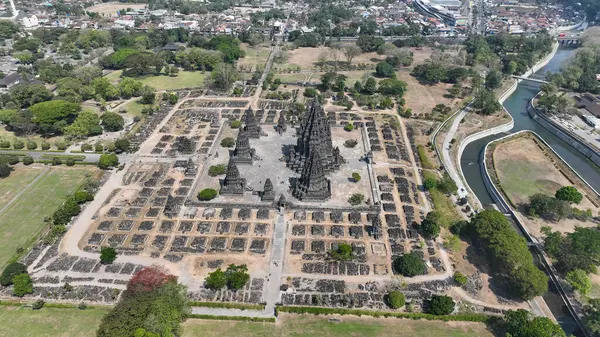 Yukarıdaki Prambanan Tapınağı kompleksi, yeşil parklar ve Endonezya 'nın merkez kenti Cava yakınlarındaki akan nehir tarafından çerçevelenmiş ikonik taş kulelerini ve geometrik kalıntılarını sergiliyor...