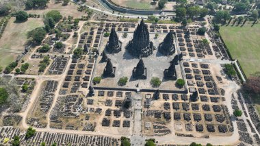 Prambanan 'ın üzerinde süzülürken, antik kalıntılarla çevrili ana tapınağın mükemmel simetrisini görebilirsiniz. Tropikal güneşin altındaki sakin bir parka kurulmuştur..