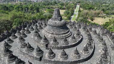 Borobudur 'un zirvesi, Endonezya' nın zengin kültürel mirasının bir vasiyeti olan taş sersemlerinden ve etrafındaki ormandan oluşan çarpıcı bir manzarayı gözler önüne seriyor..