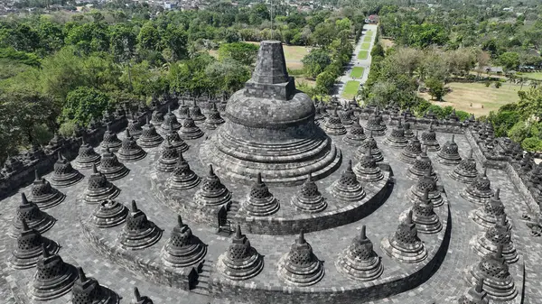 Borobudur 'un zirvesi, Endonezya' nın zengin kültürel mirasının bir vasiyeti olan taş sersemlerinden ve etrafındaki ormandan oluşan çarpıcı bir manzarayı gözler önüne seriyor..