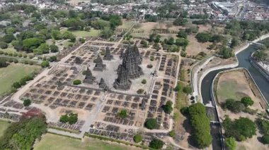 Prambanan Tapınağı 'nın havadan görünüşü, yeşil ağaçlar ve Orta Cava' nın huzurlu manzarasıyla çevrili harabelerin üzerinde yükselen antik taş kuleleri ortaya çıkarıyor..