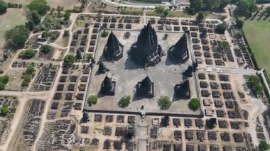 Prambanan 'ın üzerinde süzülürken, antik kalıntılarla çevrili ana tapınağın mükemmel simetrisini görebilirsiniz. Tropikal güneşin altındaki sakin bir parka kurulmuştur..