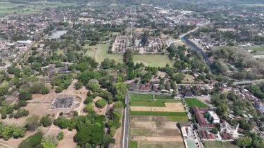 Candi Lumbung, Candi Bubrah ve Candi Prambanan 'ı görüntüler. Yeşillik ağaçların ve pirinç tarlalarının arasında geçiyor. Tapınakları Java manzarasının üzerinde yükseliyor..