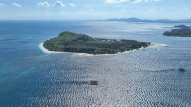 Bereketli yeşilliğin turkuaz sularla buluştuğu Tangkong Adası 'nın sakin cazibesini tecrübe edin. Geleneksel bambu balıkçılık platformları, doğal güzellik ve yerel mirasın eşsiz bir karışımını yaratarak nazikçe kıyıdan açılır..