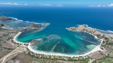 Lombok 'un çarpıcı sahil şeridi. Süpürücü beyaz plajlar, engebeli tepeler ve canlı mavi deniz. Macera ve rahatlama için mükemmel bir tropikal kaçış..