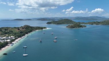 Gili Asahan yakınlarında demirlemiş yatları olan huzurlu bir körfez perspektifi. Avuç içi uzanan kıyılar ve zümrüt suları rüya gibi bir ada atmosferi sunar.