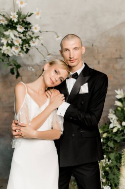 Birbirlerine aşık genç bir çift güzel kıyafetler içinde birbirlerine sarılıp gülümsüyorlar. Yüksek kalite fotoğraf